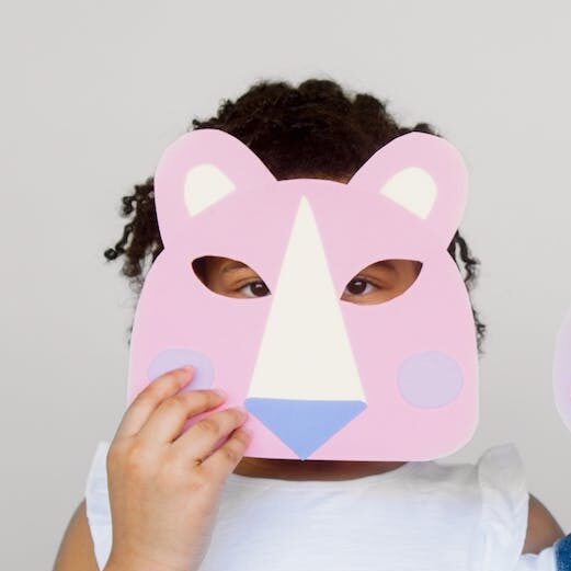 Two Kids Covering Their Faces With a Cutout Animal Mask